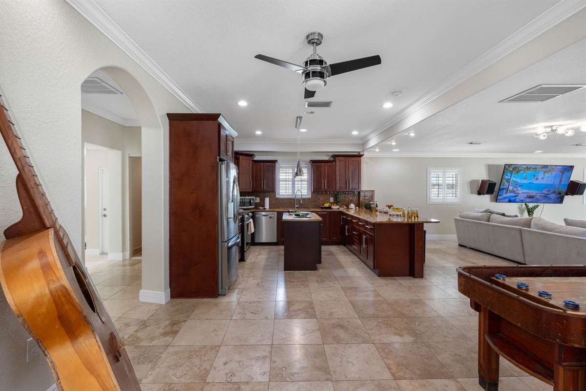 Rich cherry wood cabinetry, golden granite countertops, and a shimmering mosaic tile backsplash create a warm and elegant cooking space.
