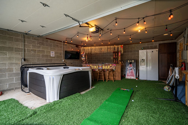 Rain or shine entertainment! Our customized Tiki garage comes fully equipped with a putting green and games, perfect for keeping kids and adults entertained. New Jacuzzi Hot Tub, Fridge, hammock, lounge chairs, tiki bar, tv, and tons of games.