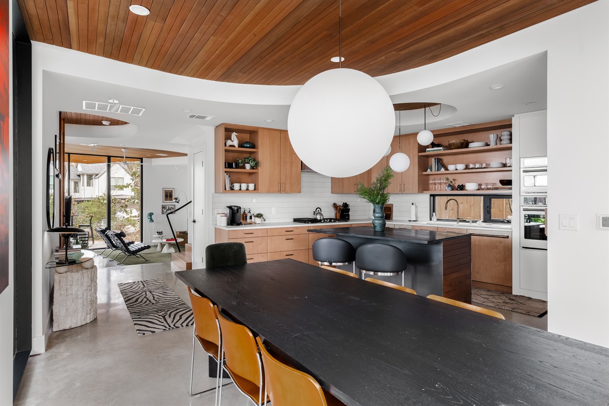 Spacious dining table under warm wood ceilings, designed for long dinners and great conversations.