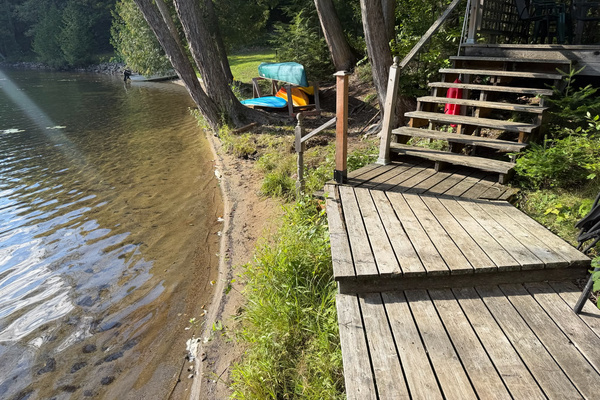 Walkway to dock and deck with sandy shore of lake