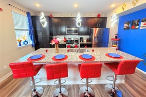 Modern kitchen + granite island with stainless appliances and bar seating for four.