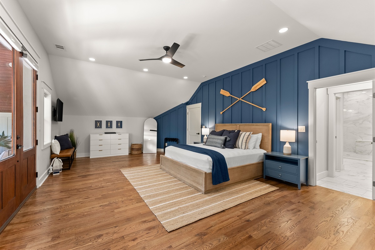 Primary bedroom opens to a private balcony with serene views.