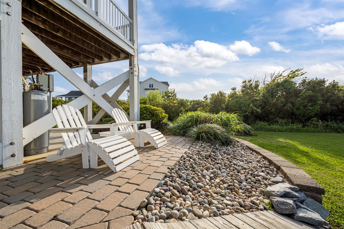 Private ground-level patio with Adirondack seating&mdash;perfect for relaxing in a quiet, landscaped setting