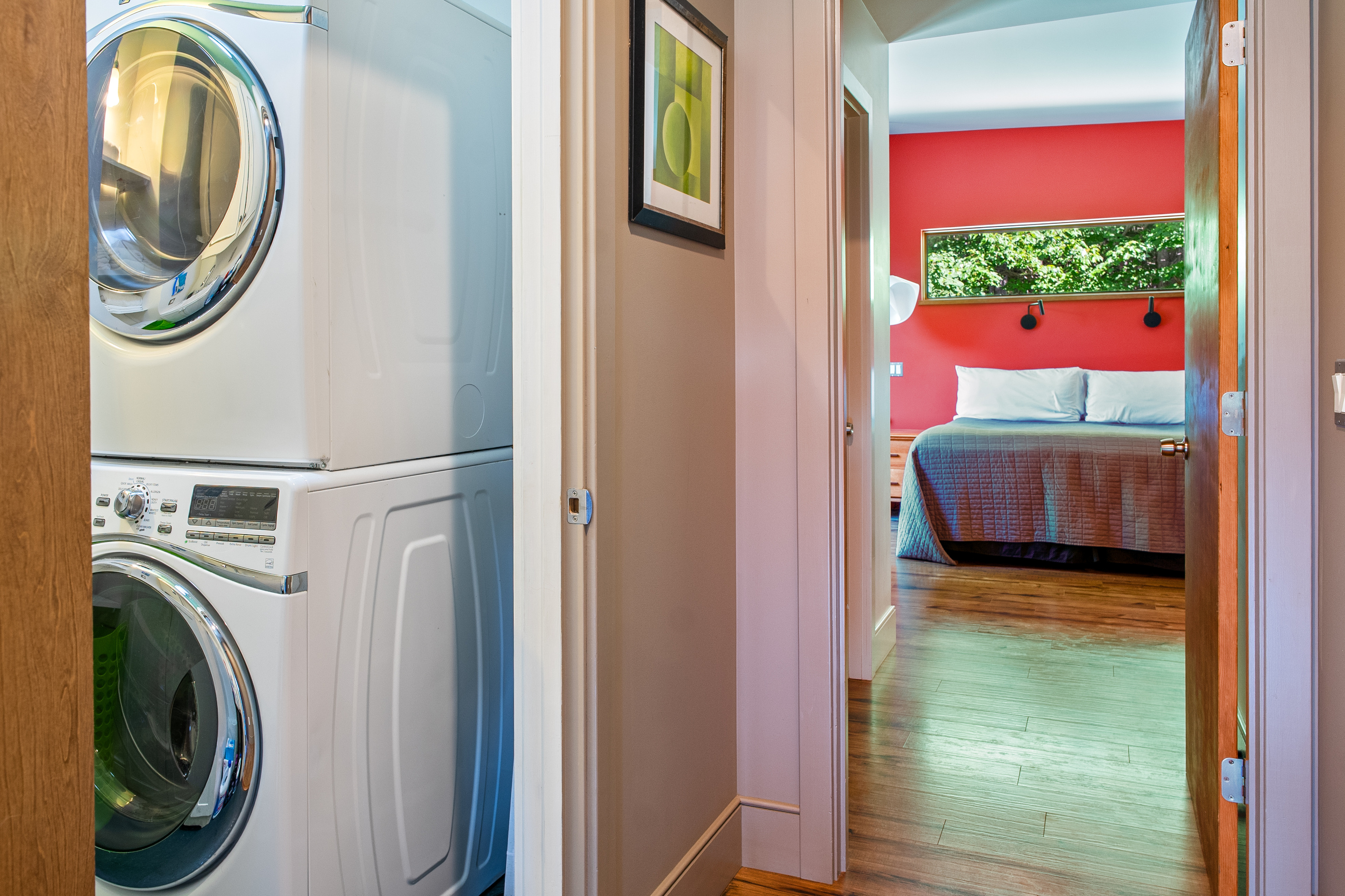 Thoughtful layout at "The Crag." The stacked washer and dryer unit sits conveniently nestled in the hallway nook, providing easy in-home laundry access just steps from the vibrant main floor bedroom suite.