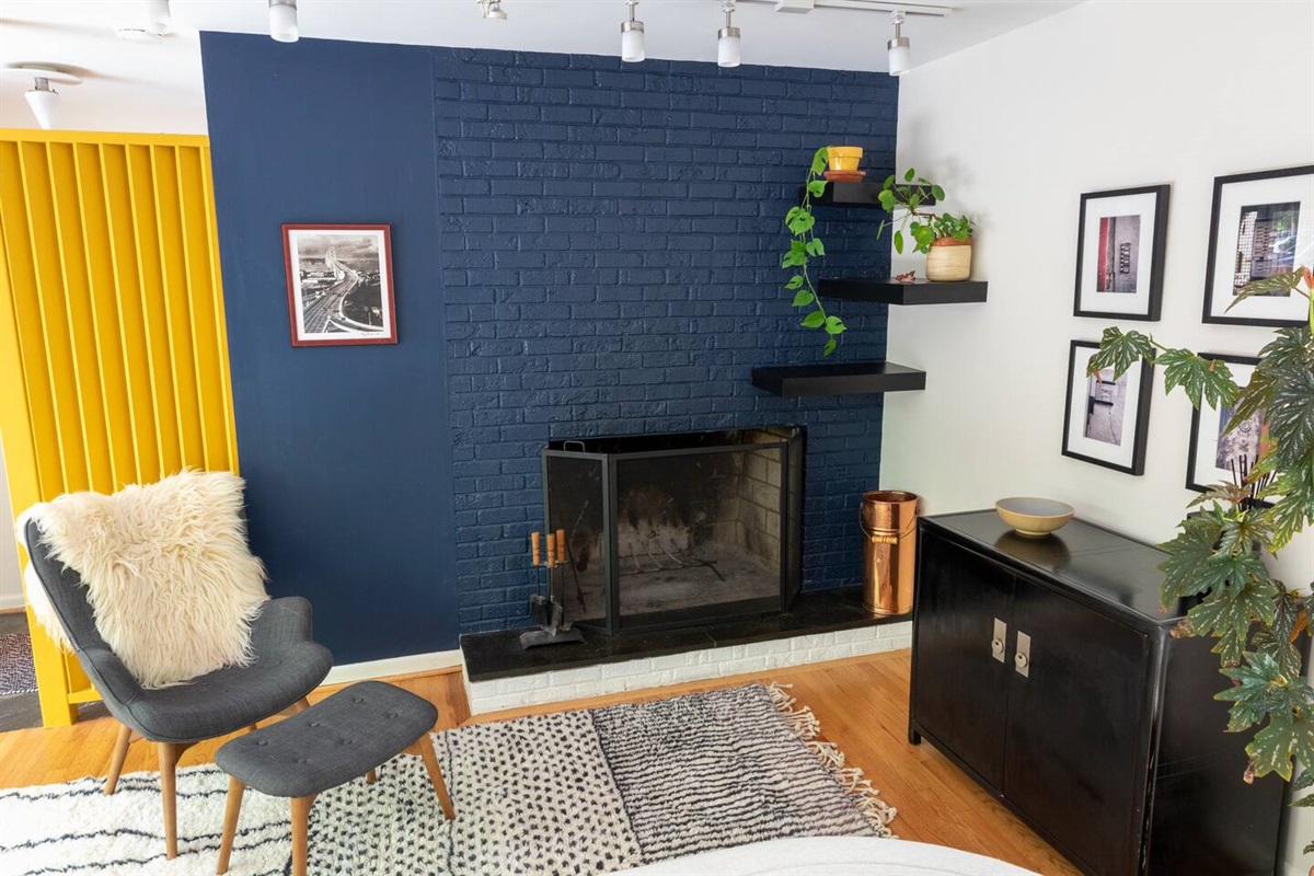 A bold yellow slat wall, a cozy fireplace, and a sheepskin chair made for sinking in &mdash; the home's most photogenic spot to do absolutely nothing.