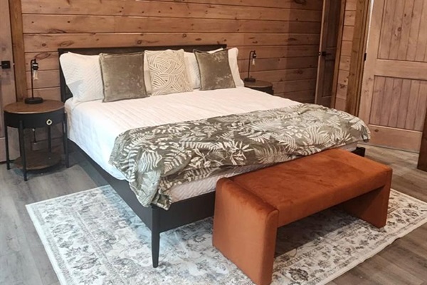 Bedroom with king bed, wood paneling, and cozy decor