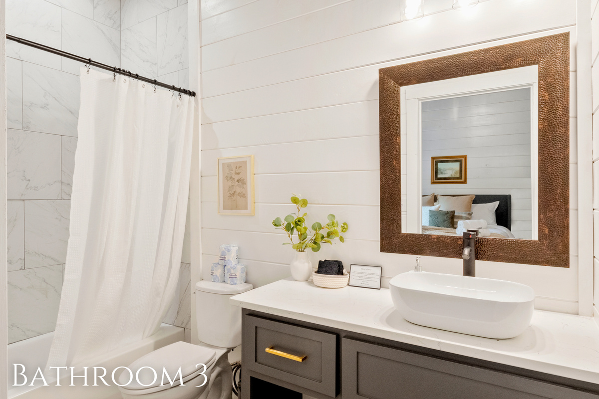 A bright bathroom with tile accents and a rustic mirror creates a space where style and relaxation meet.