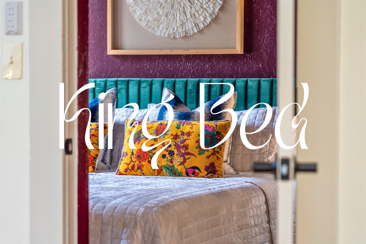 The bedroom features a bold and vibrant color palette paired with cozy bedding for a restful retreat.