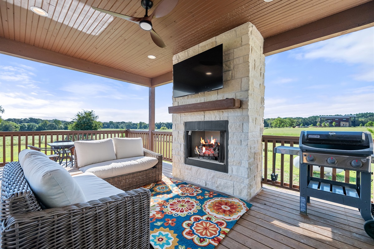 Covered patio with fireplace and grill. Ideal for outdoor lounging and entertaining while enjoying the countryside views.