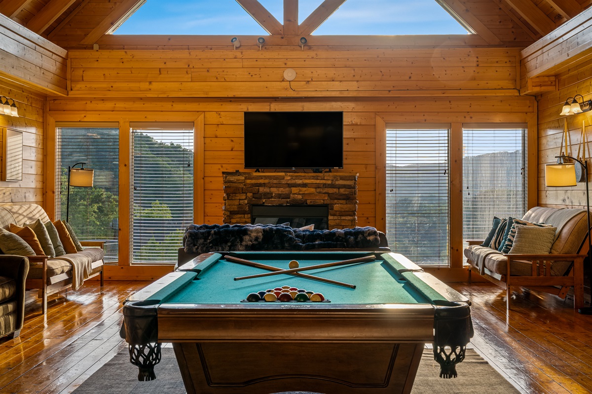 Game room with a full-size pool table, large TV, comfortable seating, and mountain views