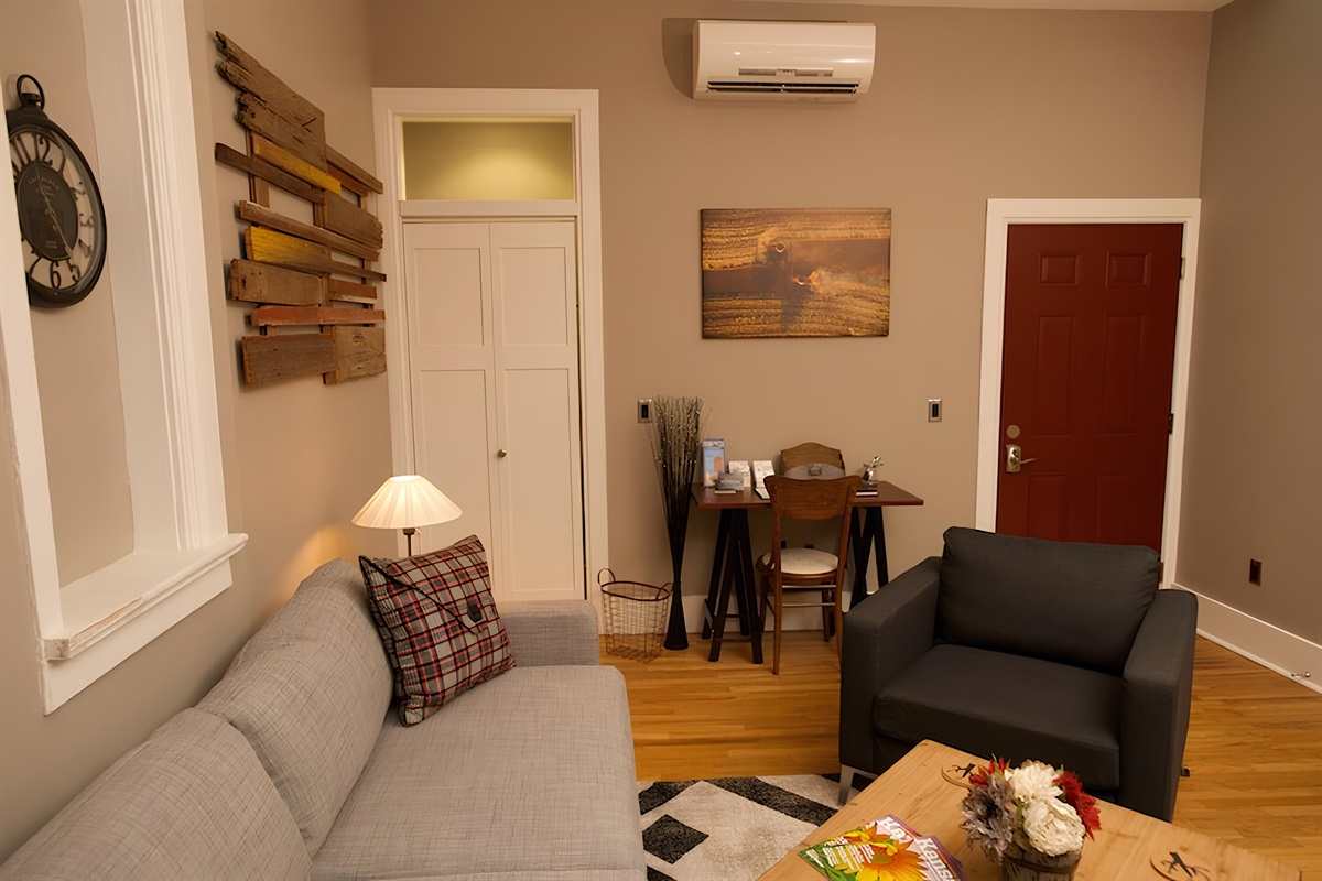 Living area offers work area with closet door on the left and door to laundry and Plantera on the right