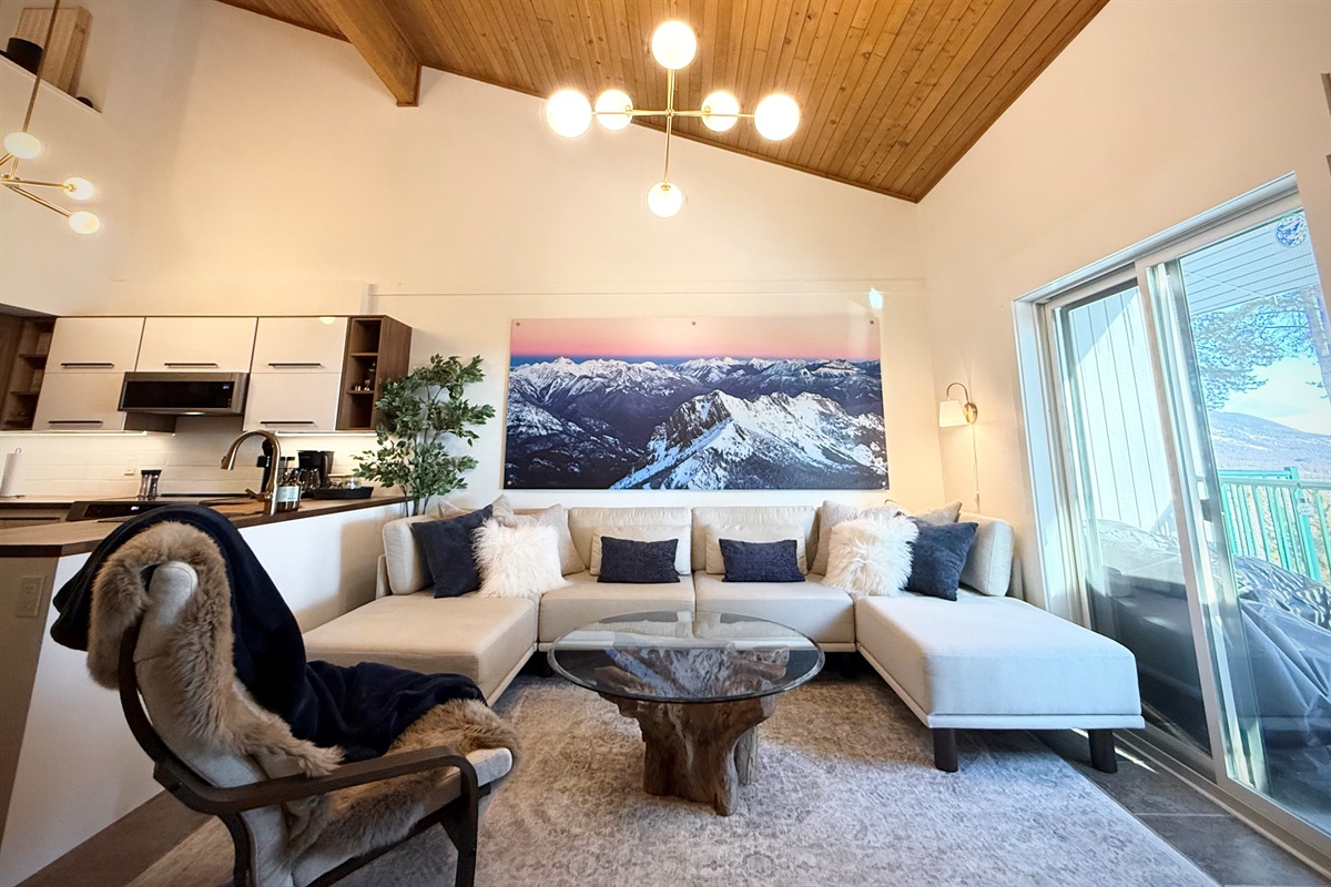 Spacious Living Area: An open-concept living room at the Kimberley ski resort townhouse features a deep-seated, cozy sofa designed for ample seating and comfort after a day on the mountain.