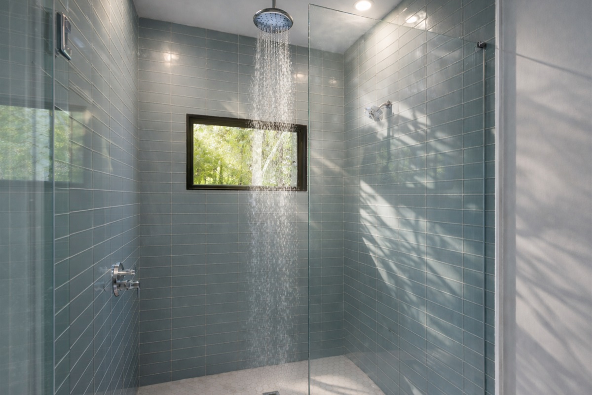 The tiled walk-in shower is a highlight of this bright and refreshing bathroom space.