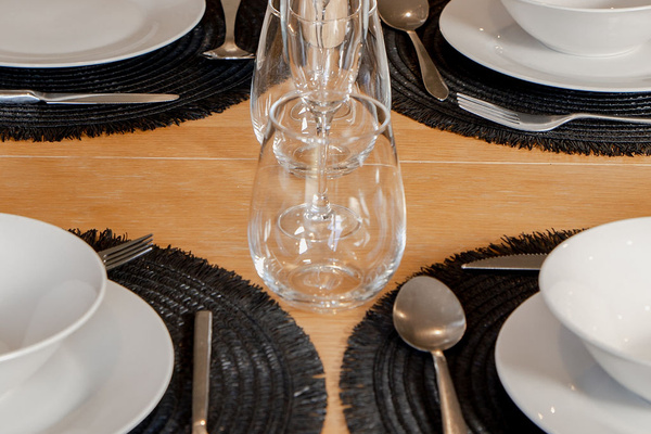 Fernhill Mountain Escape’s dining table detail adds warmth to the Queenstown stay, with place settings ready in the open-plan living area.