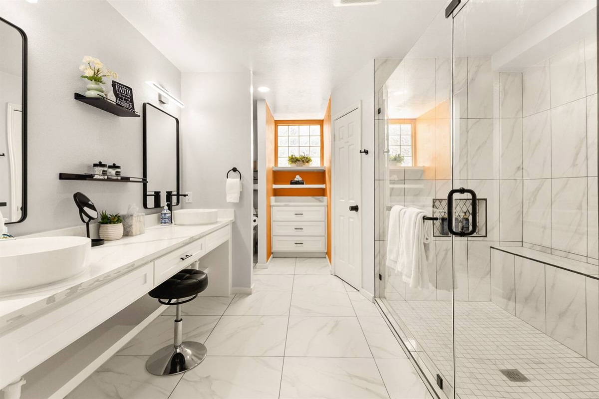 Brand-new remodeled bathroom with double vanity, modern fixtures, lighted mirrors, and a spacious glass walk-in shower. Bright, spa-like, and thoughtfully designed for comfort, convenience, and a refreshing start or end to your day.
