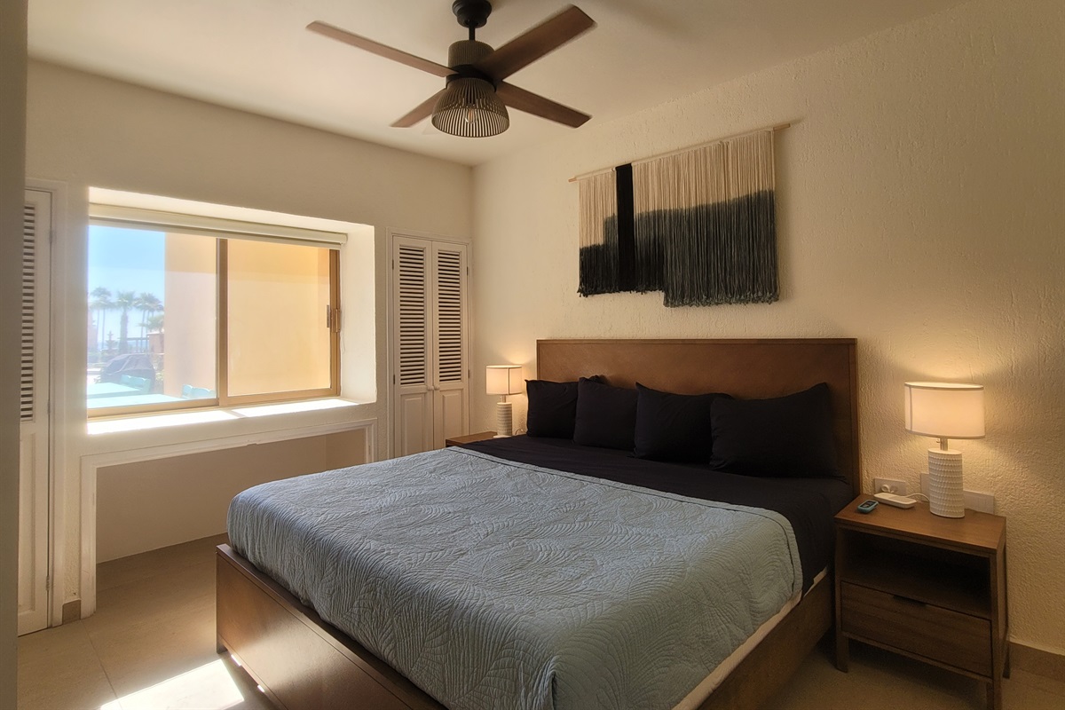 King size bed with window views of the patio and pool