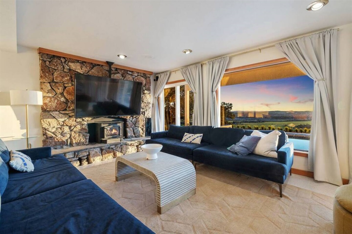 The living room is located just off the backyard. It has comfortable seating for 8 adults and a 75" 4K TV.