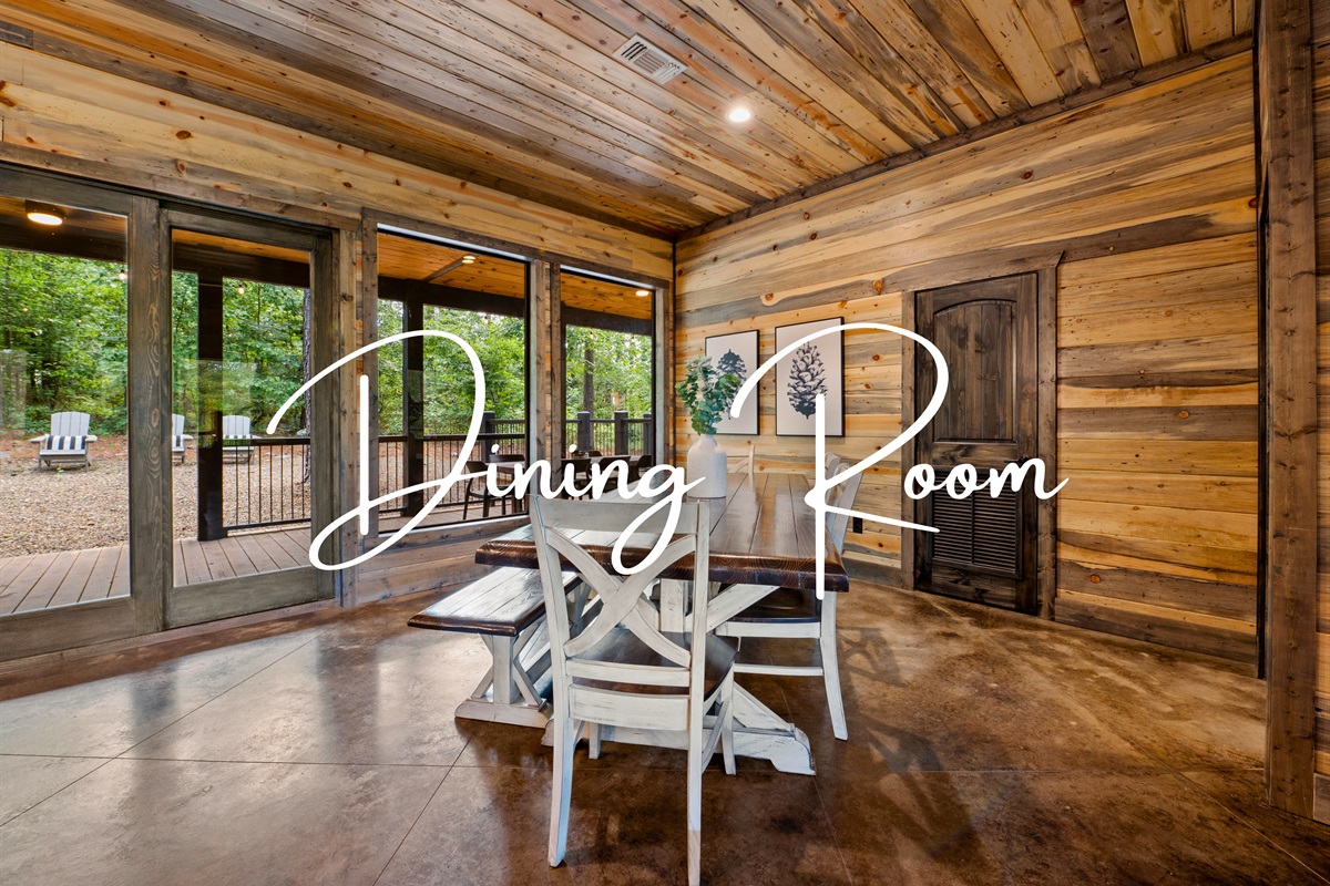 Enjoy your meals in this bright dining room with a large table, surrounded by floor-to-ceiling windows that offer panoramic views of the peaceful woodland setting.