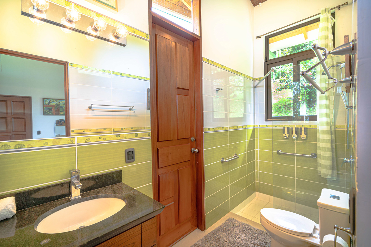Private ensuite bathroom with stone vanity and glass shower