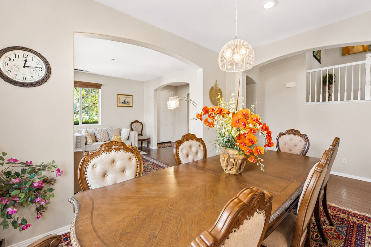 Dining room with a large table, warm wood details, and an easy view into the living room.