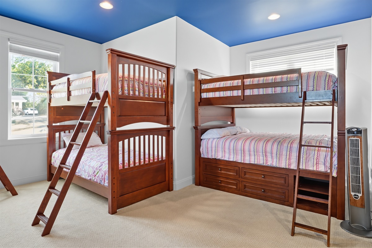 Spacious upstairs bunk room with 3 bunks featuring full mattresses on top and bottom and 2 bunks with twin mattresses on top and bottom. Bedroom #5