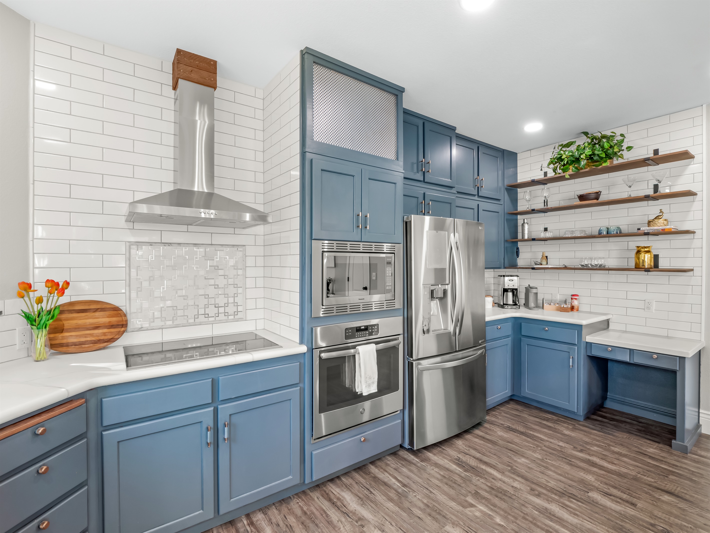 Modern chef’s kitchen featuring custom cabinetry, sleek stainless appliances, designer tile backsplash, and open shelving—an inviting space designed for effortless entertaining and elevated vacation living.