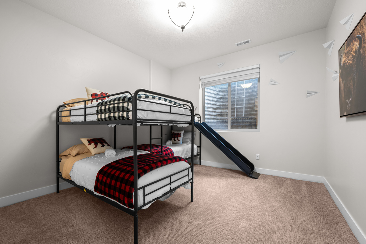 Fun bunk room with two bunk bed sets, four twin beds, and a built-in slide kids will absolutely love.