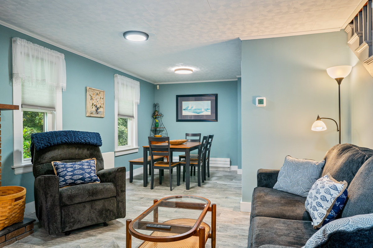 Keep everyone connected in our open-concept living and dining layout. This reverse angle shows how easily your group can transition from lounging on the sofa to sharing a meal at the table, creating a unified space for your entire Maine getaway.