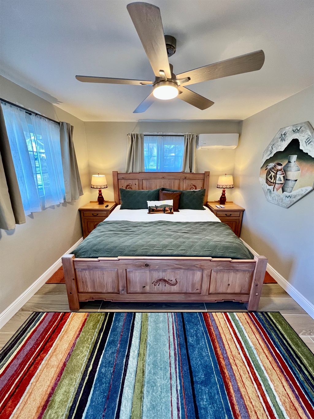 Unwind in the spacious bedroom, featuring a plush King-sized bed, a wall-mounted TV, and warm, rustic-style furnishings.