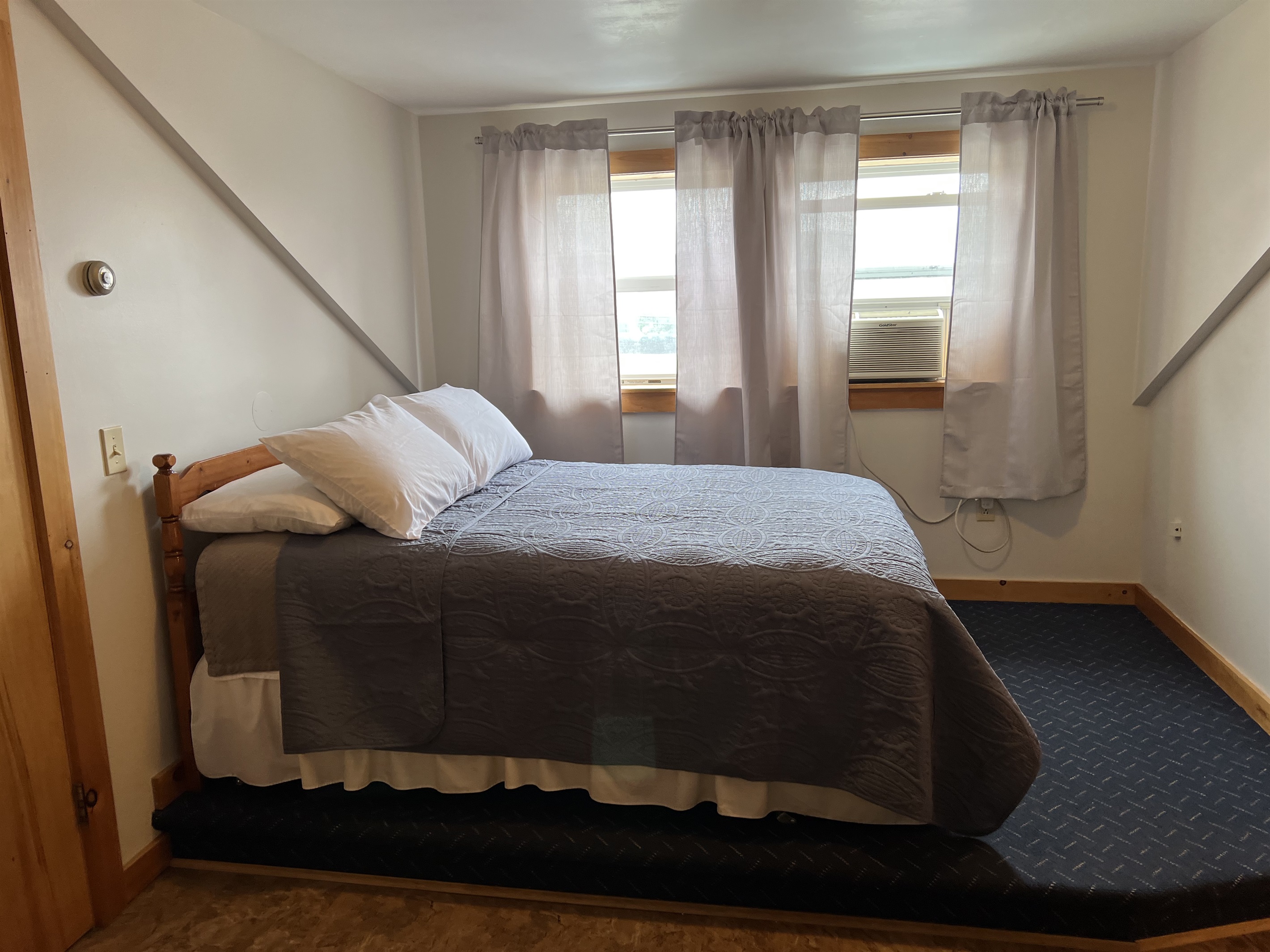 Queen bed in alcove in main area.