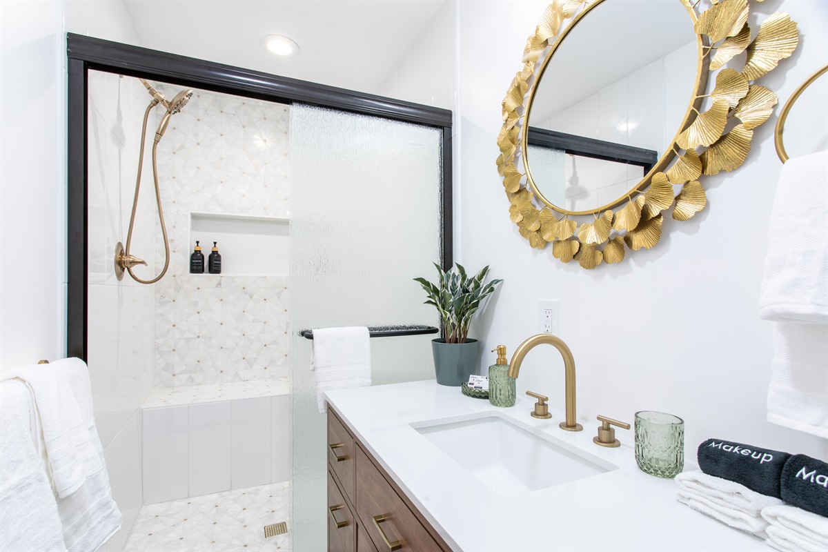 Modern walk-in shower with geometric tile, built-in shelf, and premium bath products for a spa-like experience.