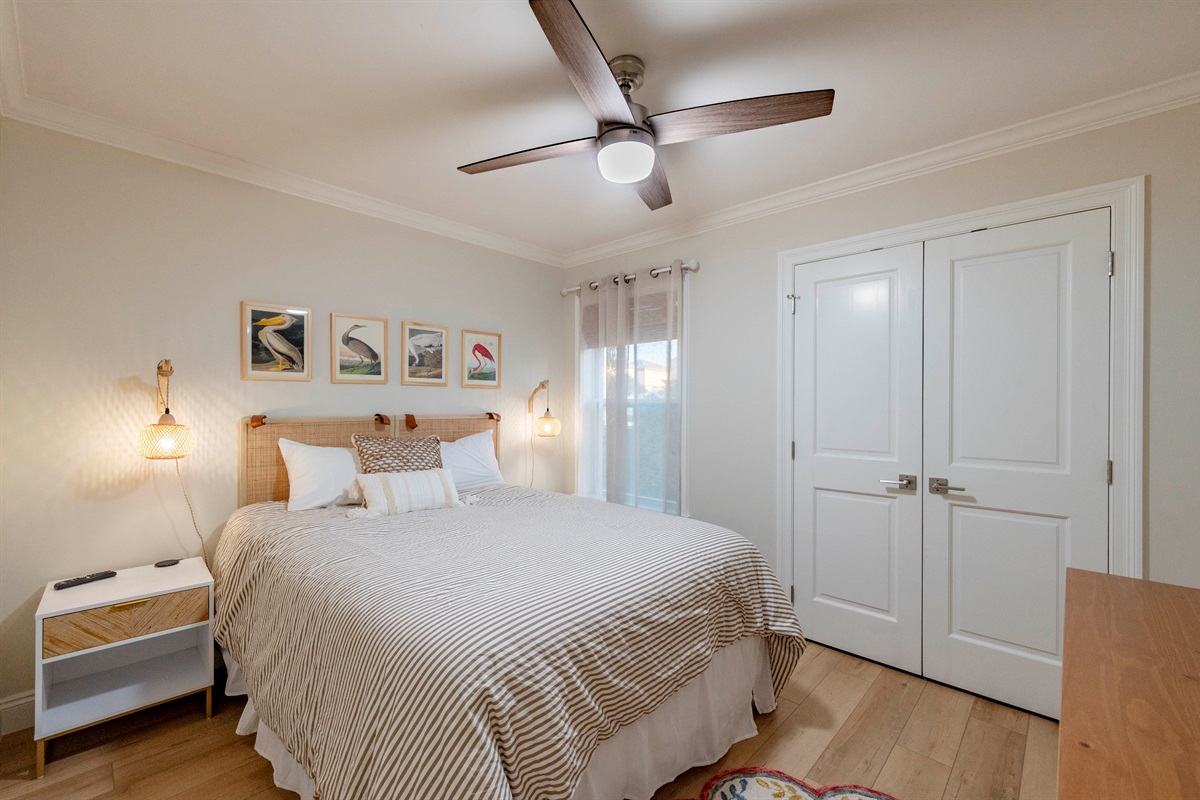 Relax in this cozy bedroom with a plush queen bed, soft lighting, and stylish decor for a restful stay!
