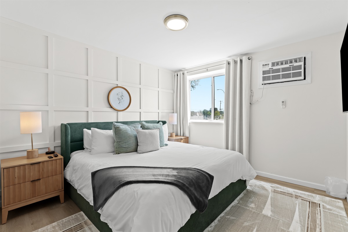 Wake up to natural light in this beautifully styled bedroom with plush pillows, mid-century nightstands, and modern comfort.