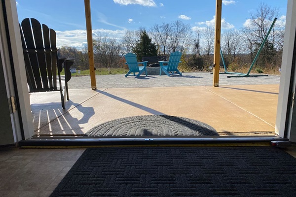 Exit to paver patio with view of chairs by fire pit