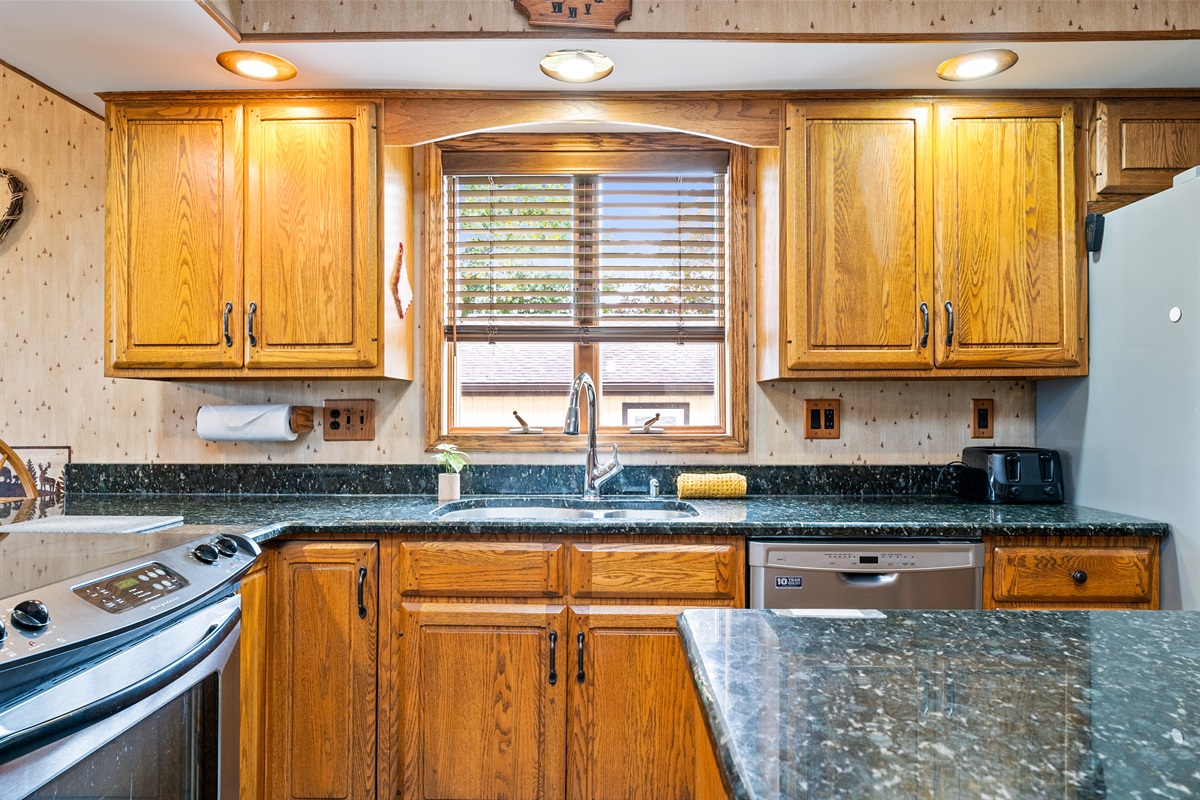 Charming kitchen view featuring warm cabinetry, plenty of light, and everything you need to feel at home.