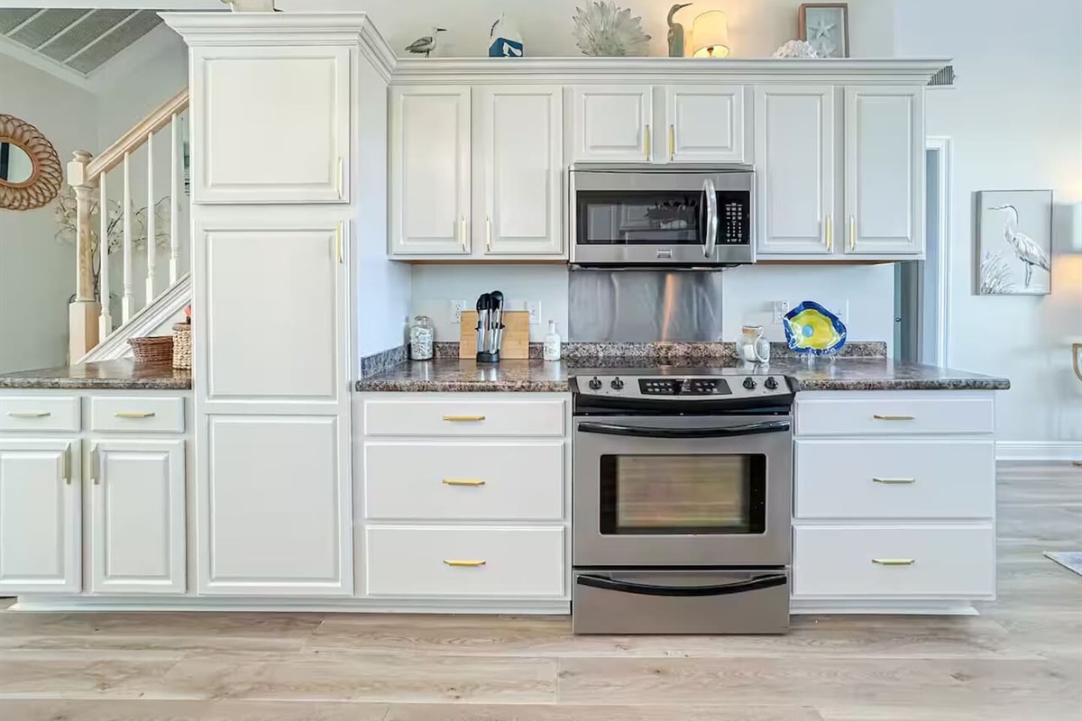 Spacious, sunlit kitchen featuring ample counter space, stainless steel appliances, and stylish lighting, perfect for cooking and entertaining.