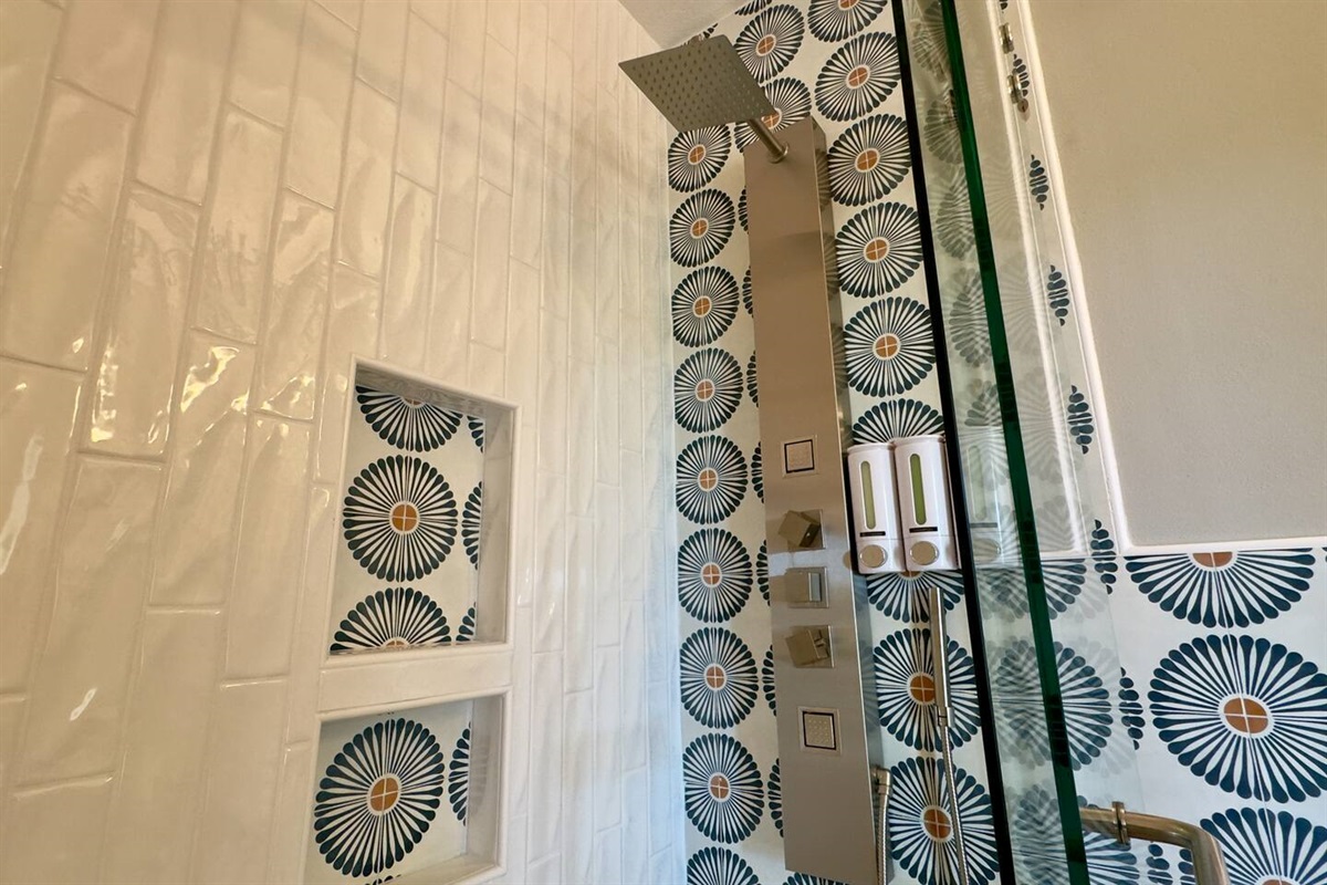 Built-in recessed shelves with matching patterned tile keep toiletries organized and stylish.