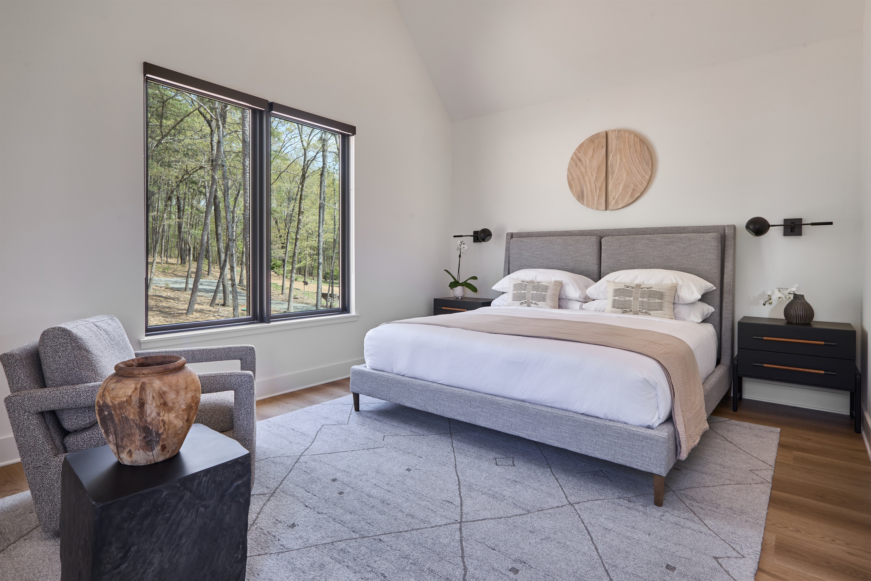 A sophisticated neutral palette, tailored headboard, and ample space make this king suite feel like a boutique hotel stay.
