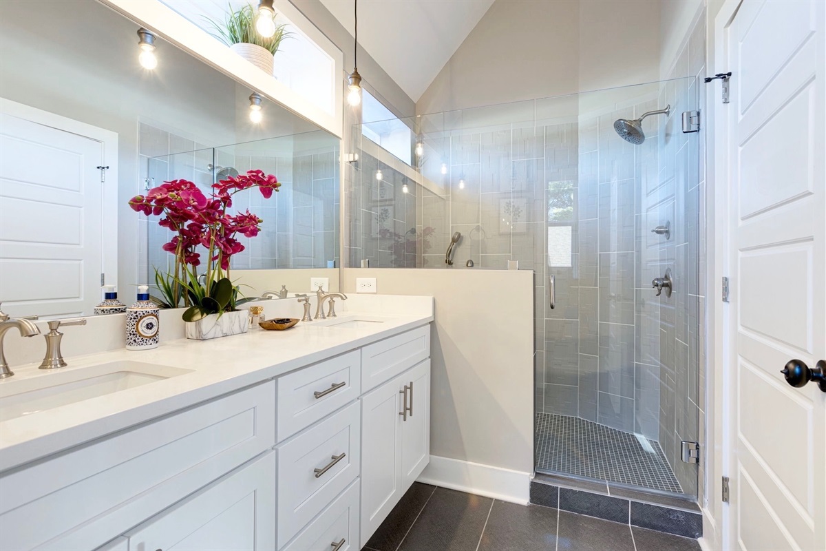 - Step into spa vibes with a sleek walk in shower and bright, airy design - Double sinks, fresh florals, and glowing vanity lights add stylish function - From morning refresh to evening wind down, this space feels like a treat