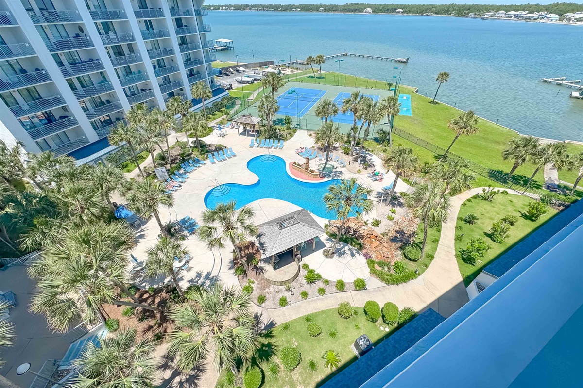 A tranquil waterside escape awaits. This inviting pool and patio area, complete with comfortable loungers and dining tables, offers the perfect spot to relax and soak in stunning views of the bay.
