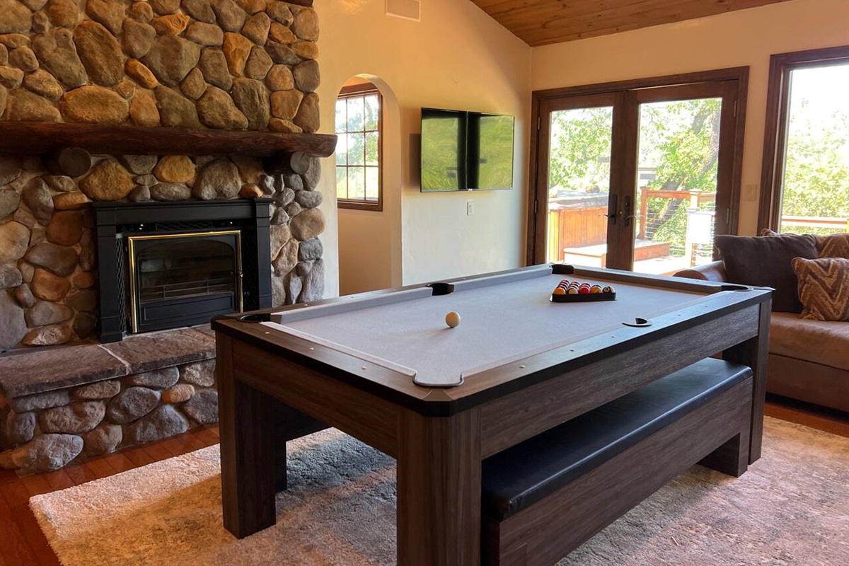 A second living room with a pool table, additional ping table topper, speaker system, and 55" 4K TV.