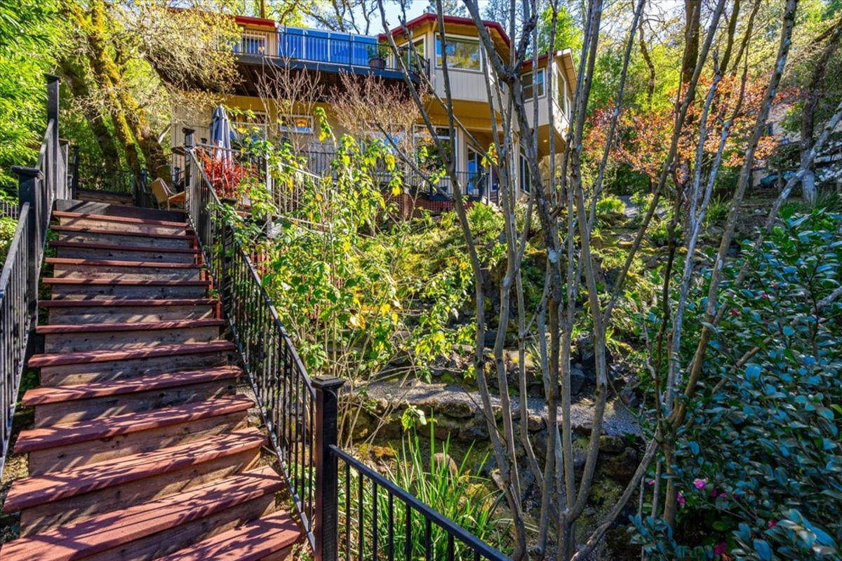 Descend the stairs from the house to enter a lush garden oasis.
