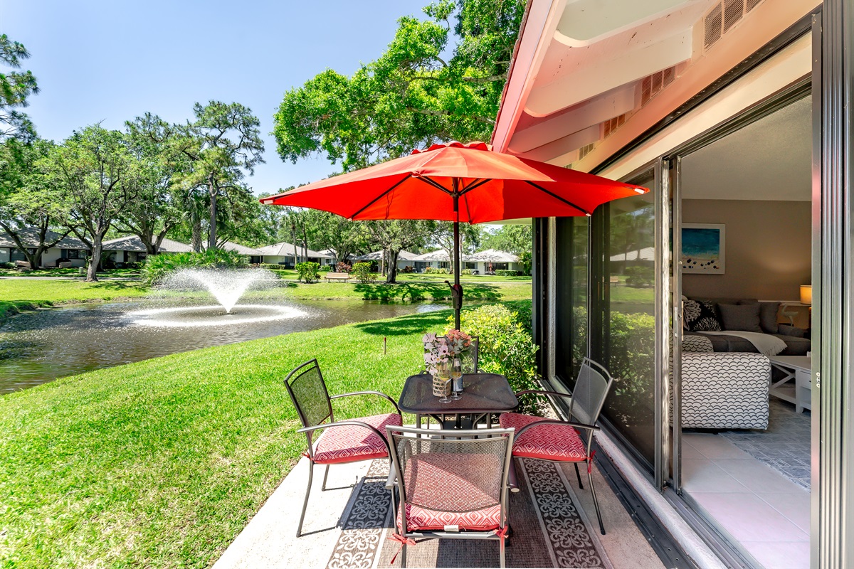Private lakeside patio with outdoor dining, umbrella, and grill—perfect for morning coffee or sunset meals by the water
