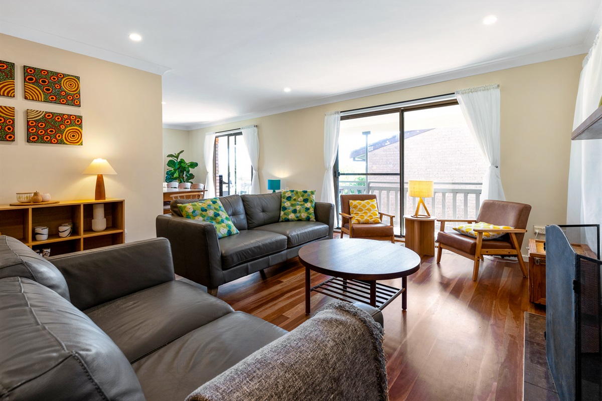 The lounge seating faces the open fireplace, giving Bertie’s 3 Beaches a clear central living space on the upstairs level.