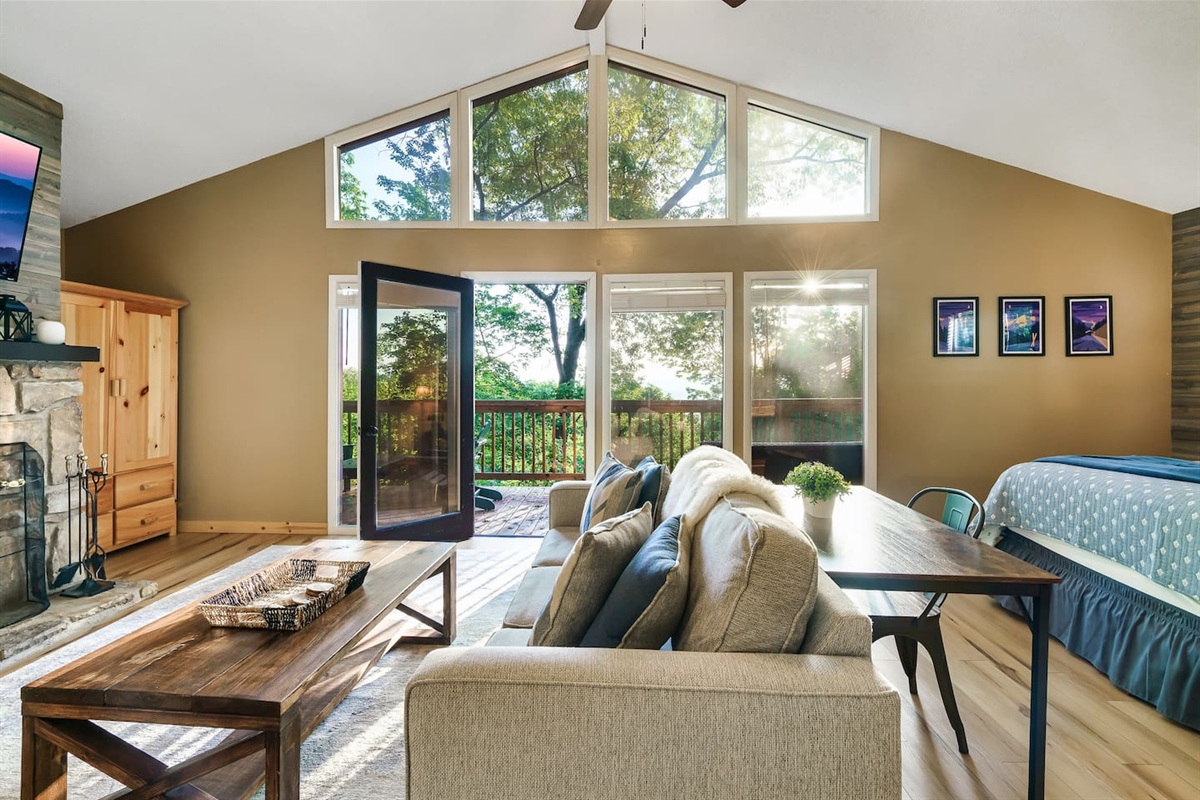 The private master bedroom suite features its own living area, private bathroom, stone fireplace, vaulted ceiling, and a private deck.
