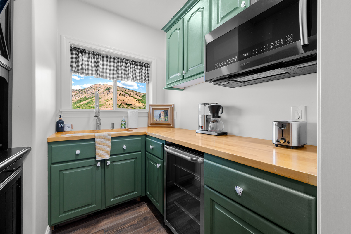 The beautifully appointed pantry offers additional counter space, a sink, microwave, coffee maker, toaster, and beverage refrigerator for added convenience.