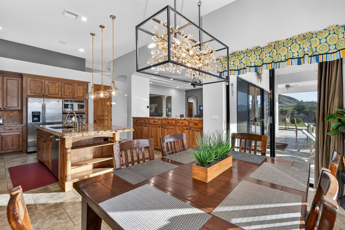 Formal dining space with statement lighting and open kitchen connection designed for memorable group dinners