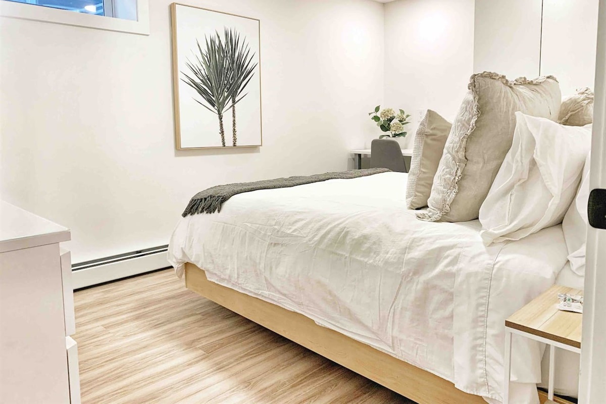 Comfortable queen bed with quality linens designed for a good night’s sleep.