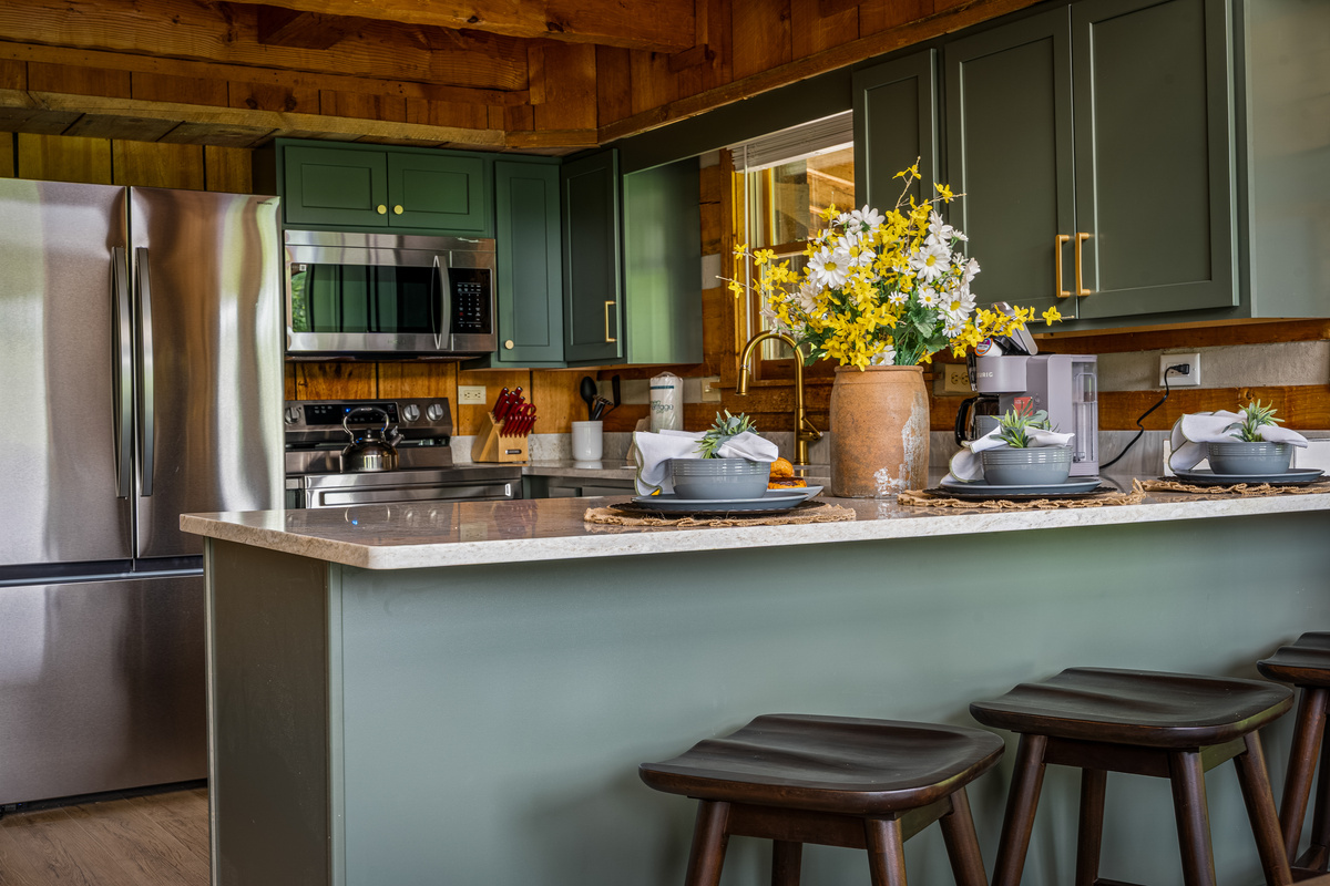 Bar stools at the kitchen bar provide additional seating options for meal time.