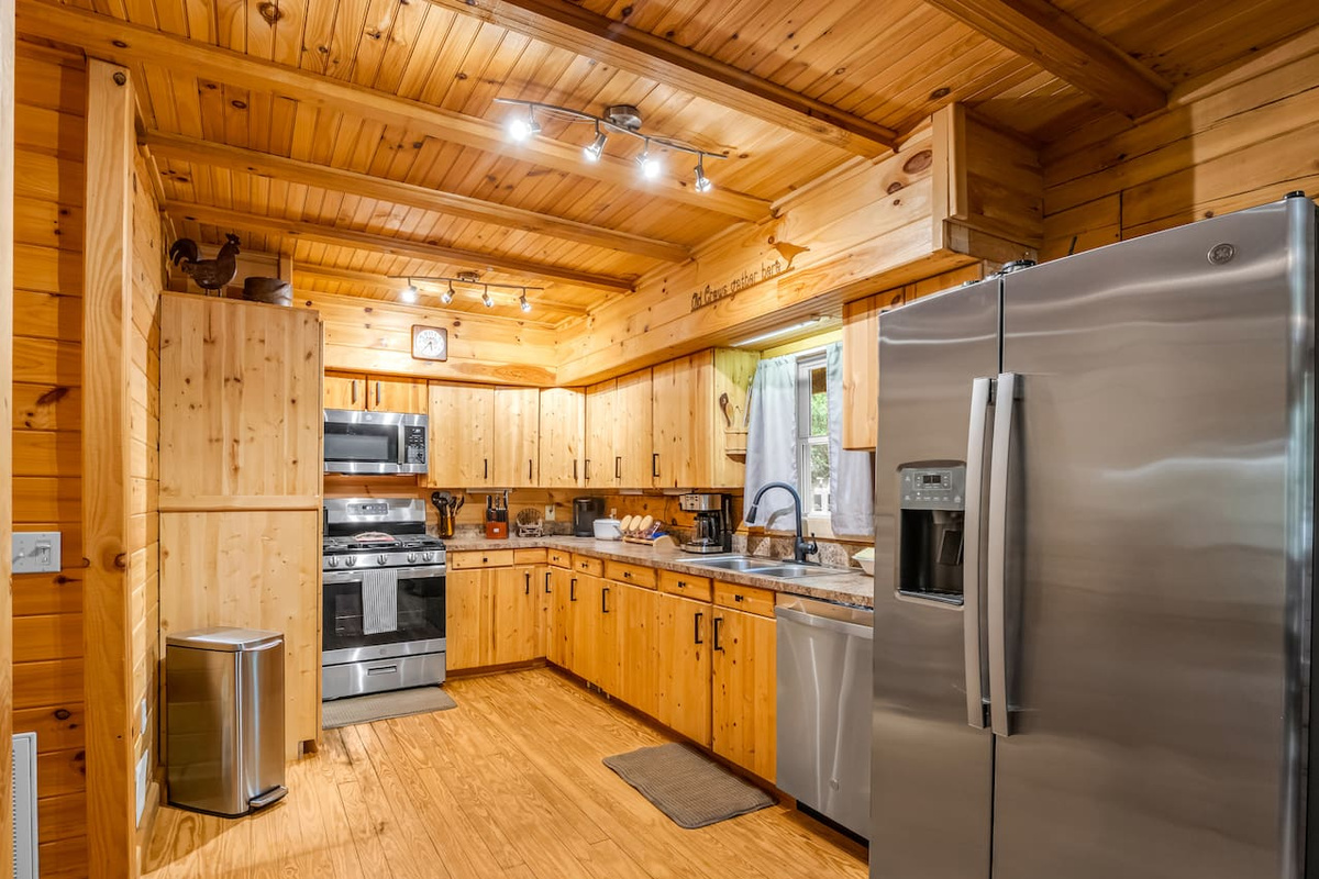 Fully equipped kitchen featuring stainless steel appliances, ample counter space, and rustic cabin charm 